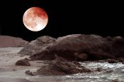 red-moon-over-rocks-and-sand