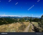 stock-photo-beautiful-utah-landscape-with-blue-skies-and-mountains-dirt-road-path-for-atv-24957114431
