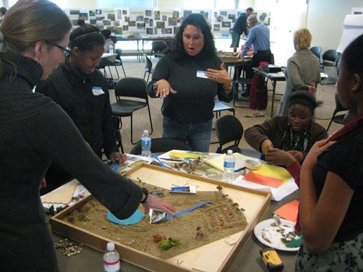 Community members working with sand models at the WeDesign  workshop 